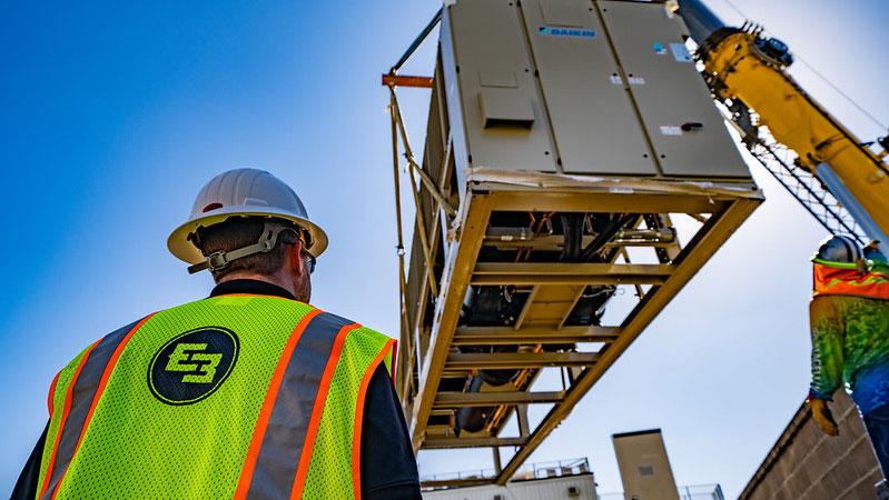 E3 construction worker viewing a crane in operation
